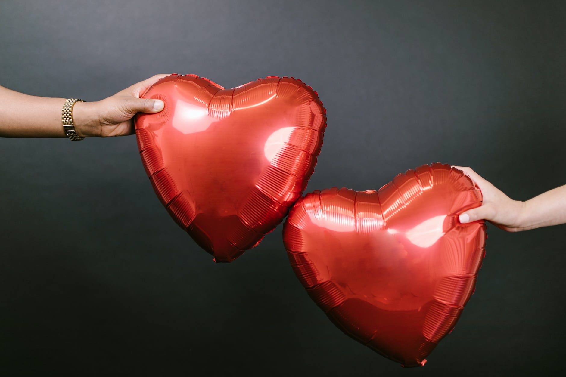 two persons holding two red heart shaped balloons the 5 love languages