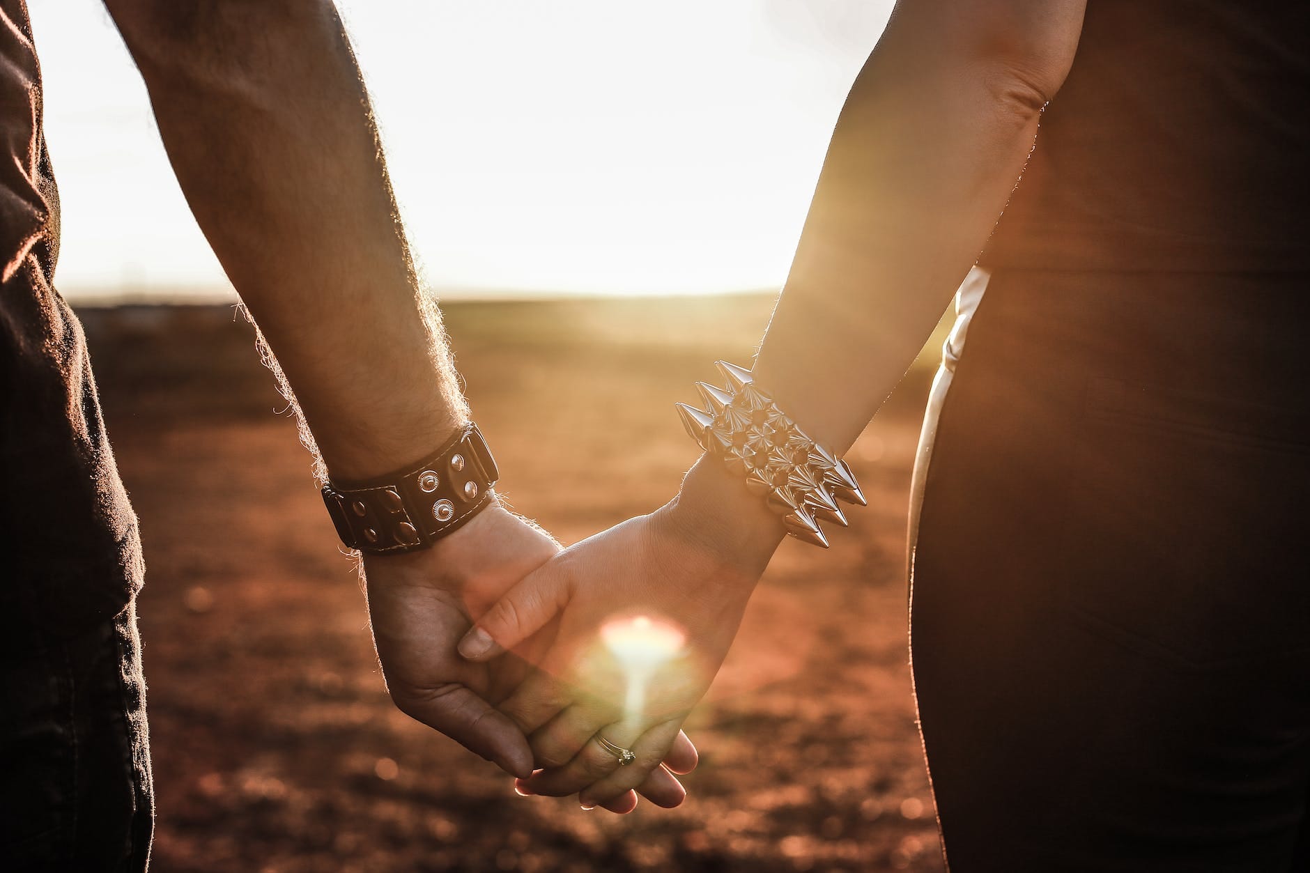 people standing in front of sunlight while holding hands