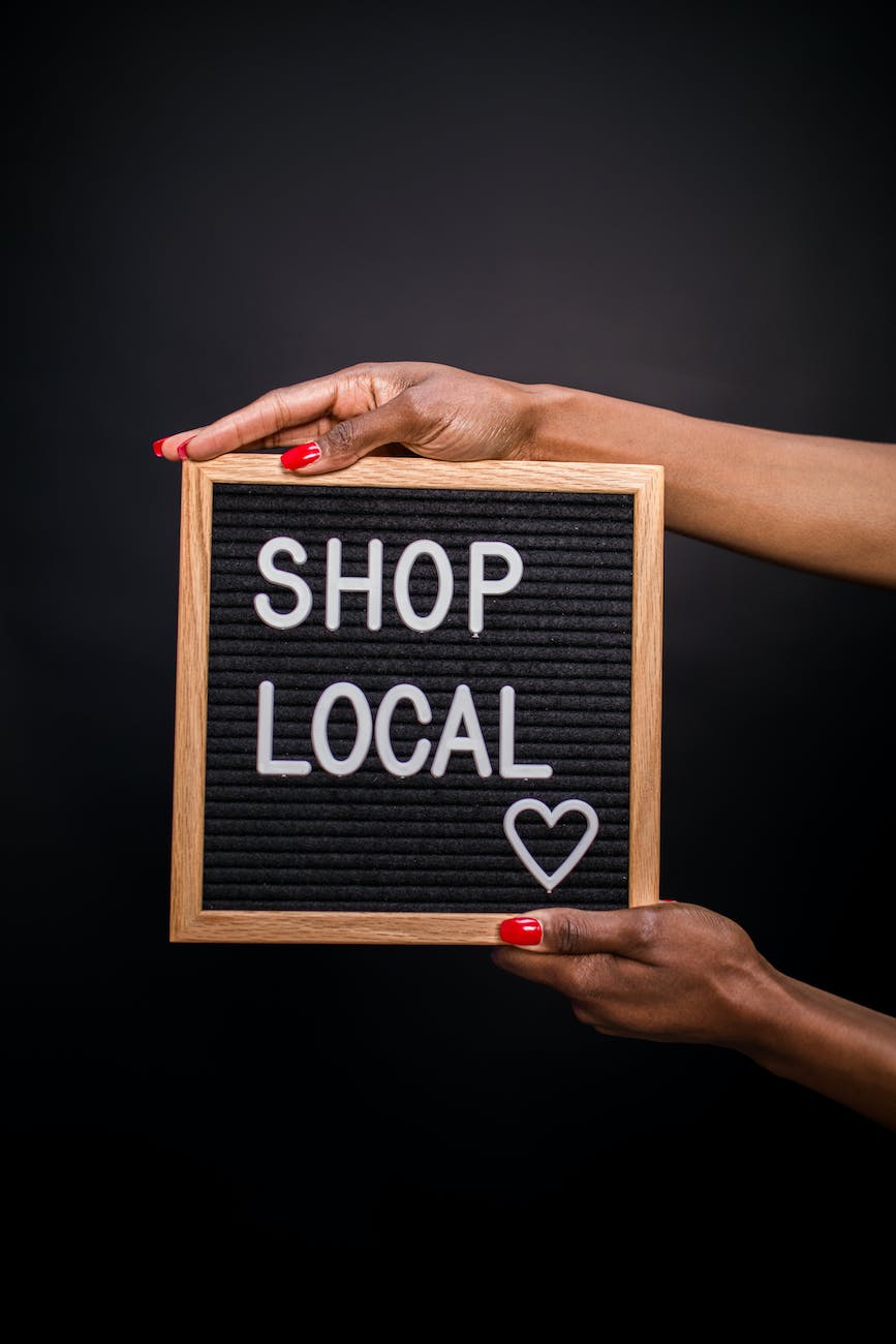 a person holding a letter board with shop local text. Creative Shopping Captions for Instagram