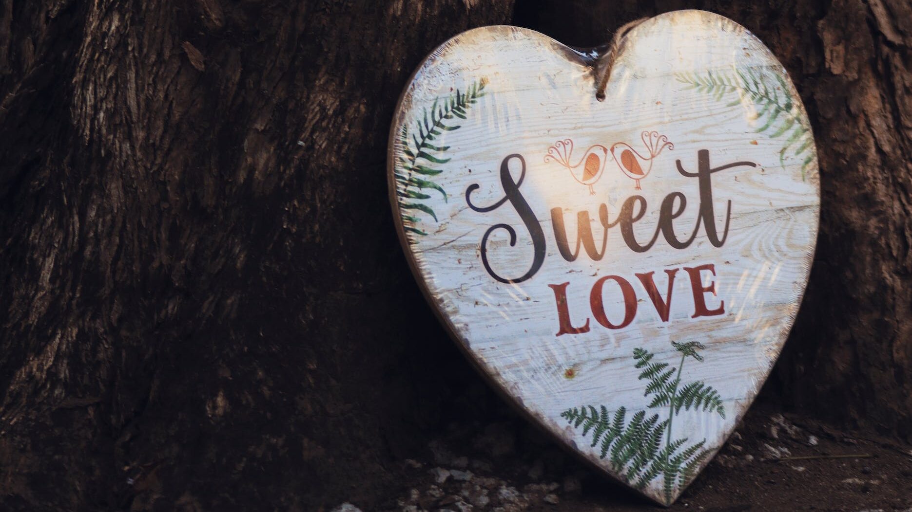a heart shape wood board with sweet love text