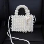 Luxury white handbag entirely covered in pearls and beads with a ribbon detail