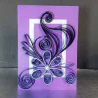 Detailed purple quilling card with complex flower and swirl design, showcasing intricate paper art techniques