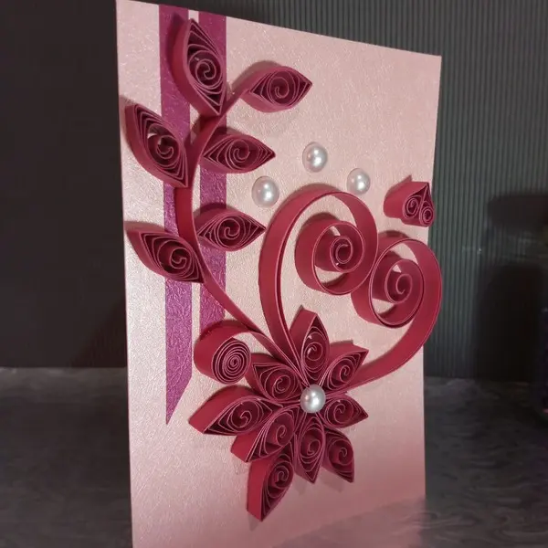Handmade card for her featuring pink quilled paper art in the shape of a heart with floral elements and pearl embellishments
