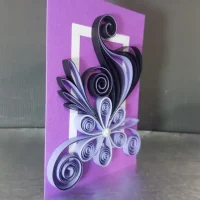 Detailed purple quilling card with complex flower and swirl design, showcasing intricate paper art techniques